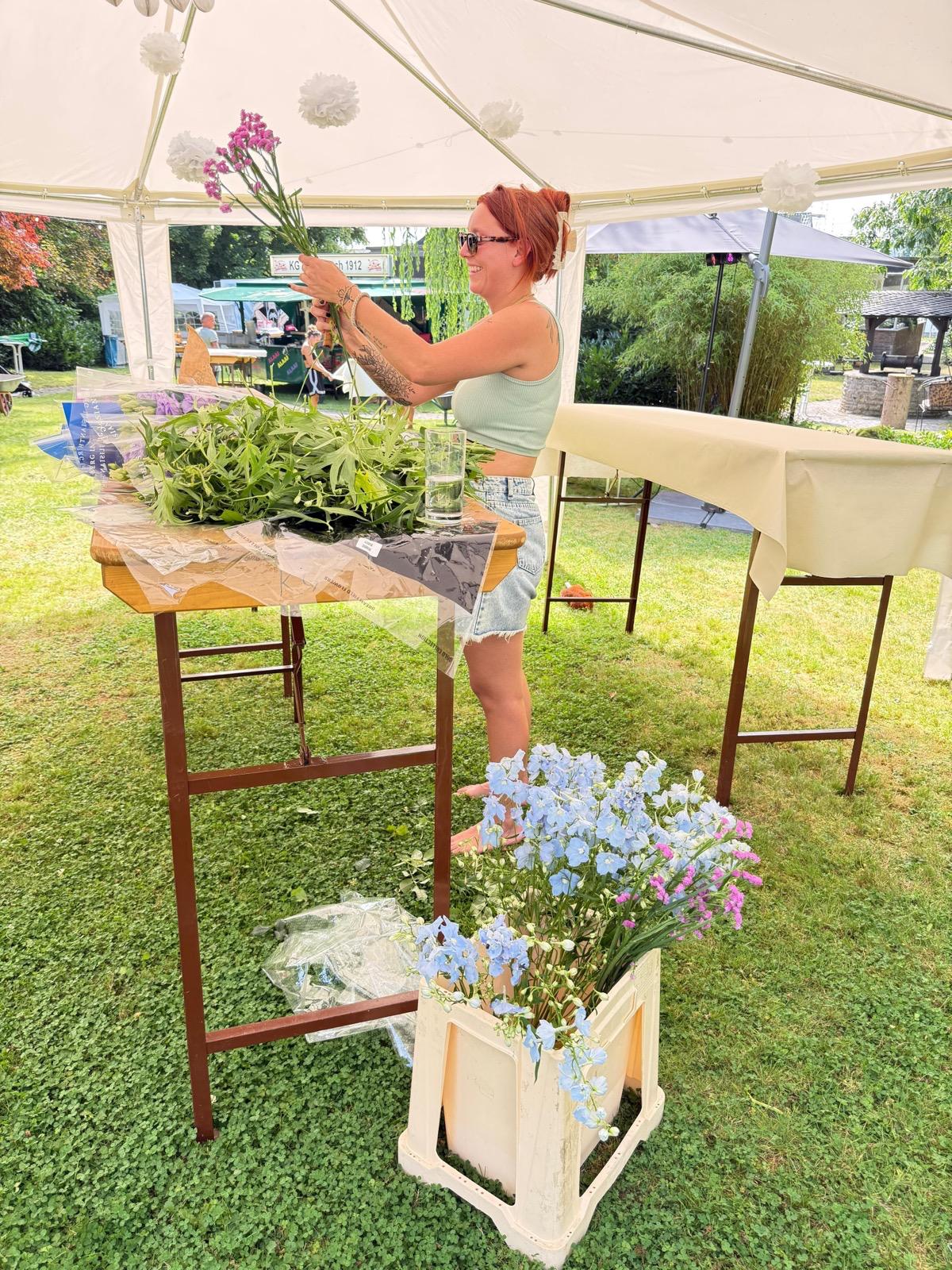 Miri beim Dekorieren mit rosa Blumen und Rittersporn